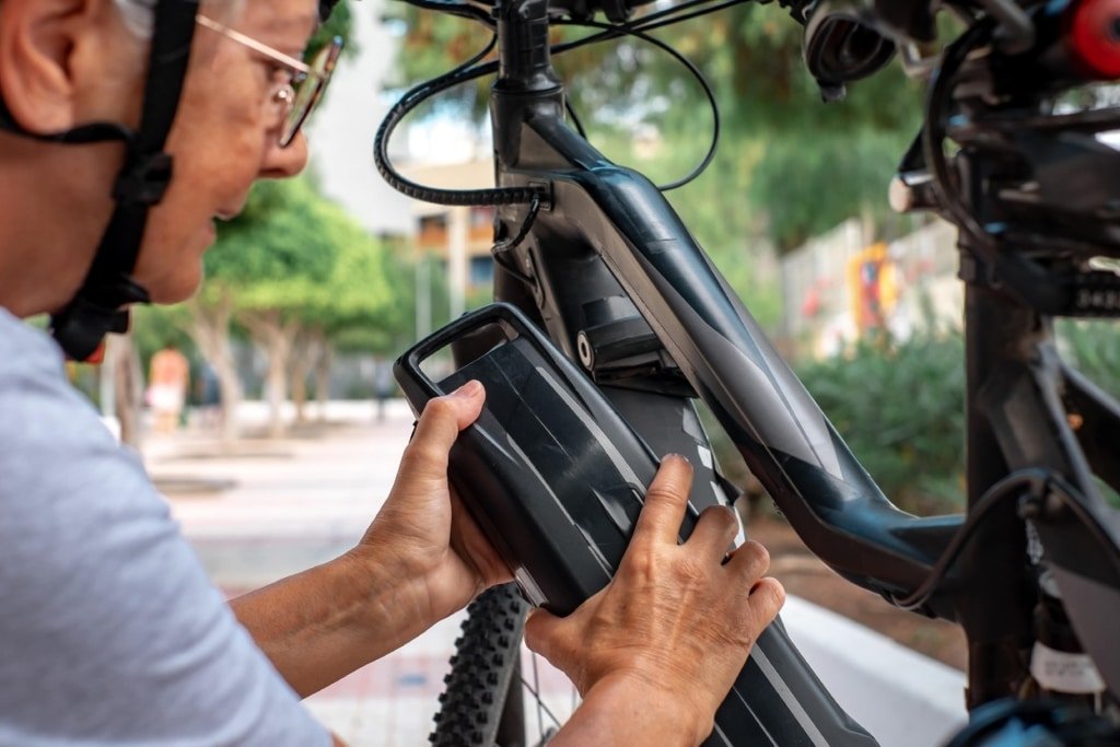 אישה מרכיבה סוללה על אופניים חשמליים